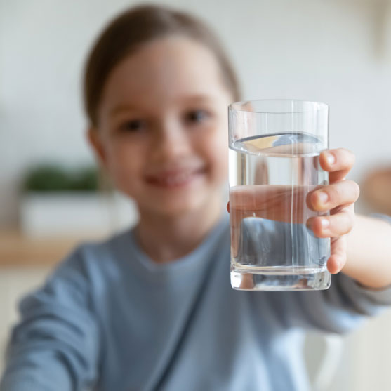 Girl holding glass of water to camera